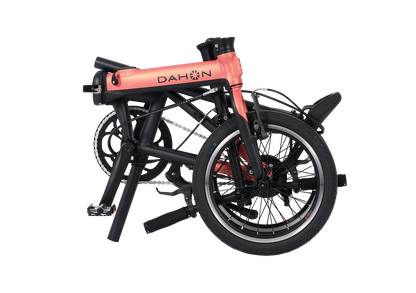 DAHON K-Feather electric bike in blush pink, shown folded for compact transport.